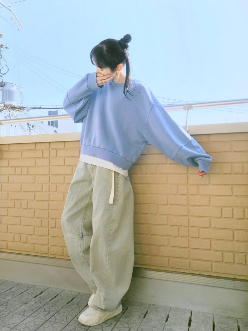 ホワイト系のスニーカー、ブルー系のデニムパンツ、ブルー系のスウェットを着用したレディースの冬コーディネートの2枚目の写真