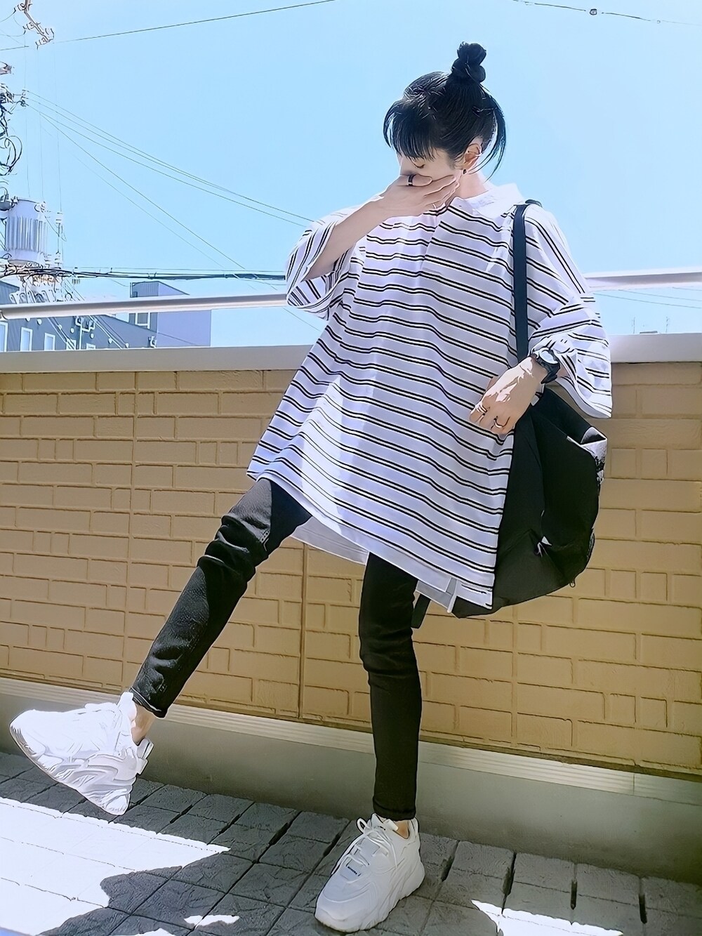 ホワイト系のポロシャツ、ブラック系のデニムパンツ、ホワイト系のスニーカーを着用したレディースの夏コーディネートの2枚目の写真