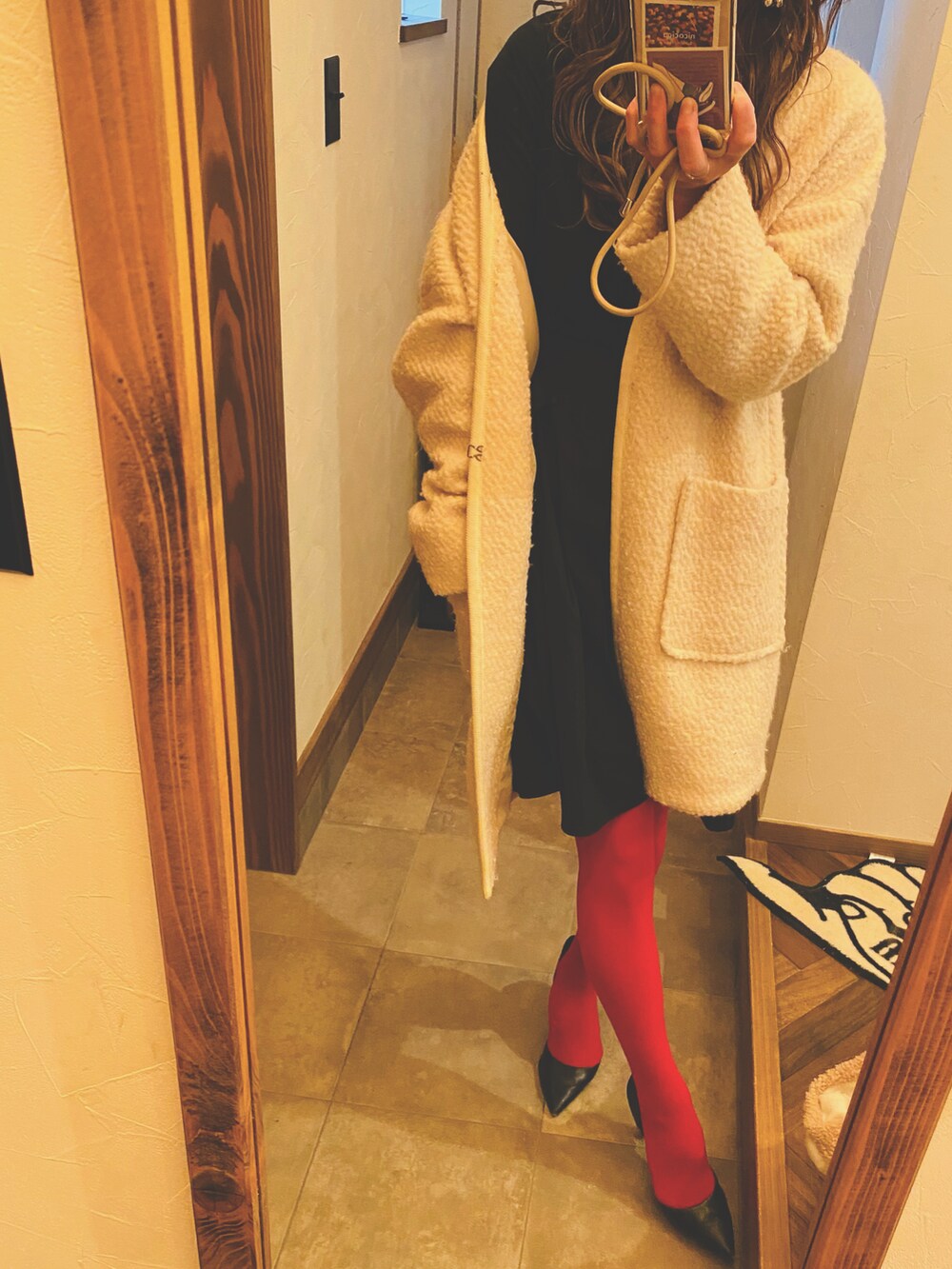 ホワイト系のジャケット/アウター、ブラック系のワンピース、ブラック系のパンプスを着用したレディースの冬コーディネートの2枚目の写真