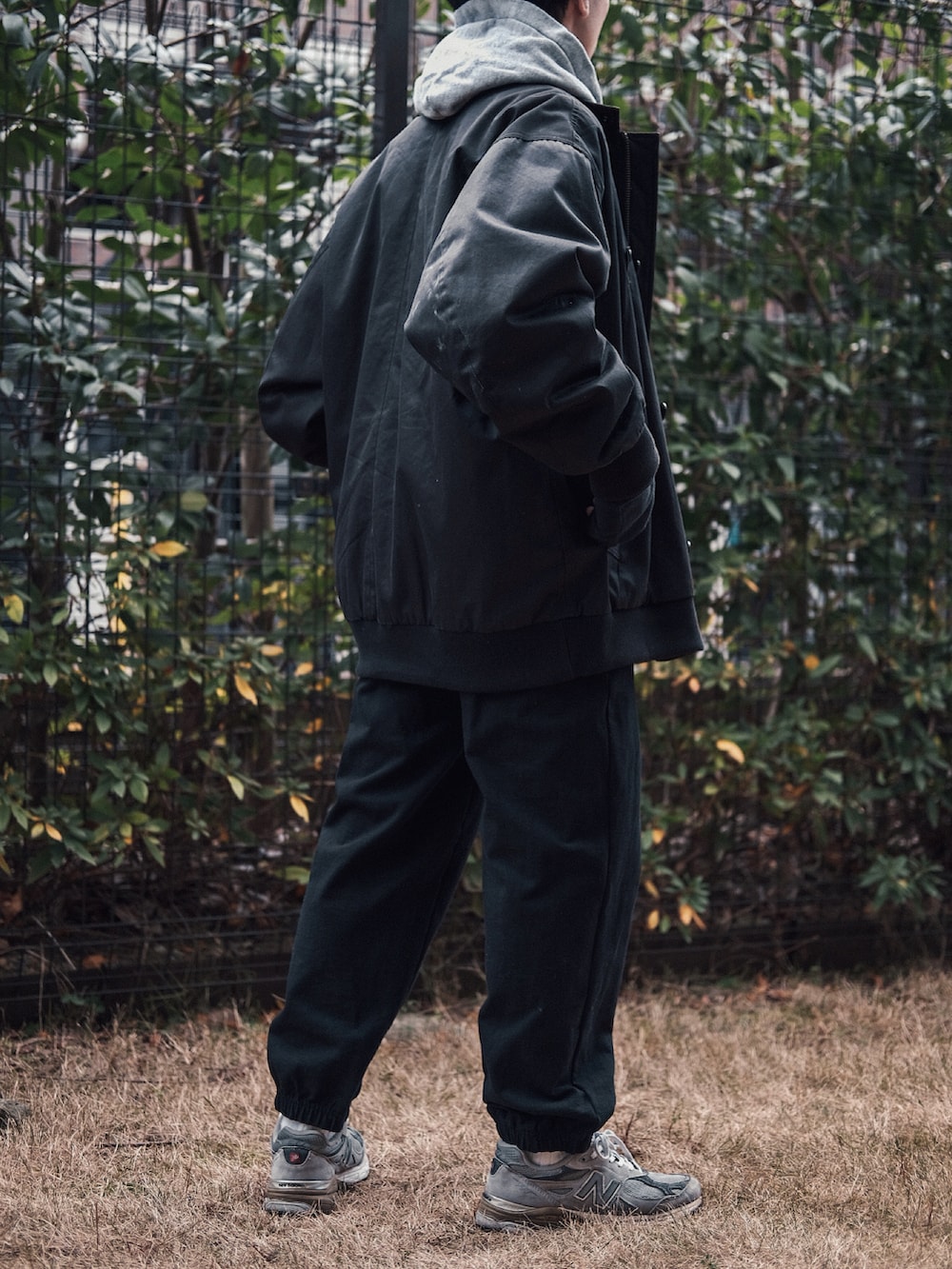 ブラック系のブルゾン、グレー系のスウェット、グレー系のスニーカーを着用したメンズの冬コーディネートの3枚目の写真