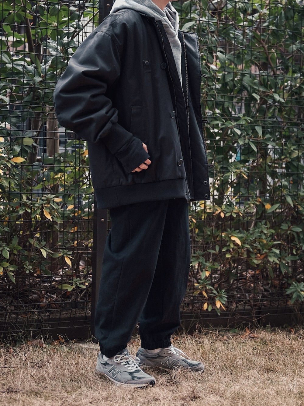 ブラック系のブルゾン、グレー系のスウェット、グレー系のスニーカーを着用したメンズの冬コーディネートの2枚目の写真