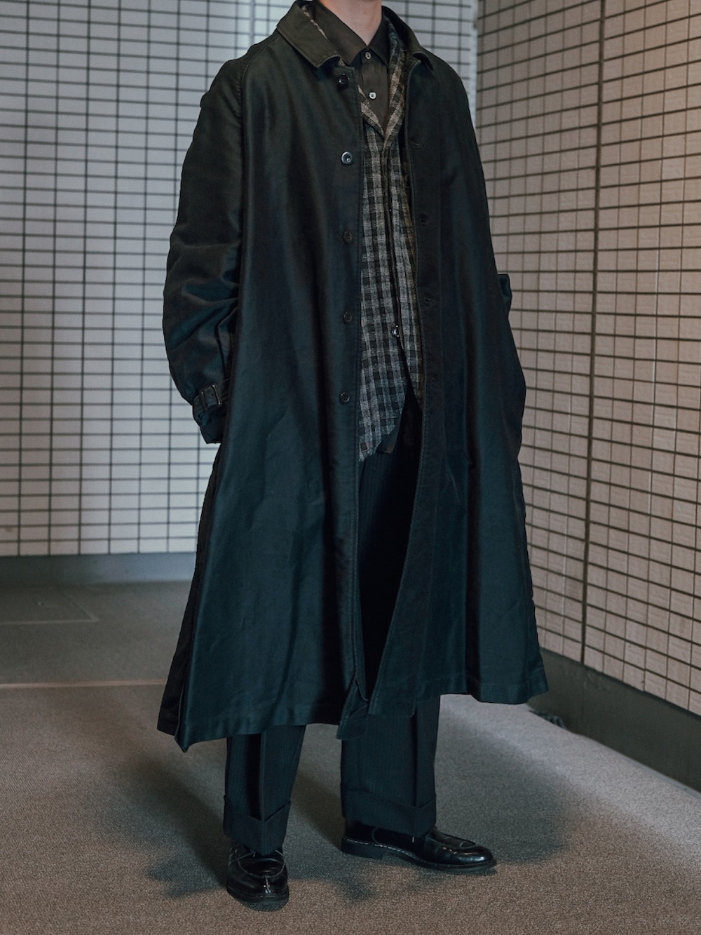 ブルー系のステンカラーコート、ブラック系のテーラードジャケット、ブラック系のシャツ/ブラウスを着用したメンズの冬コーディネートの2枚目の写真