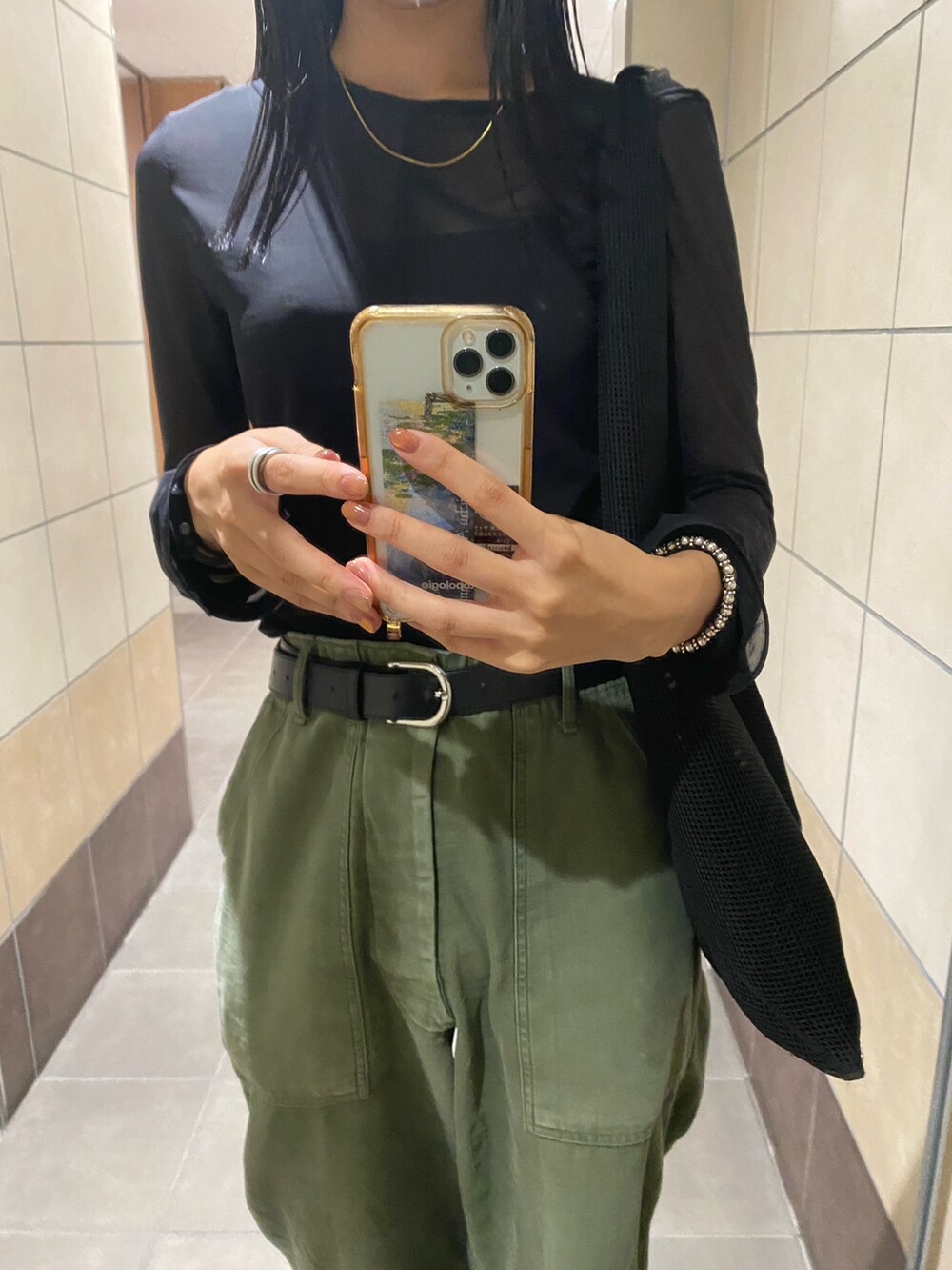 グリーン系のパンツ、ブラック系のトートバッグ、ブラック系のサンダルを着用したレディースの夏コーディネートの2枚目の写真