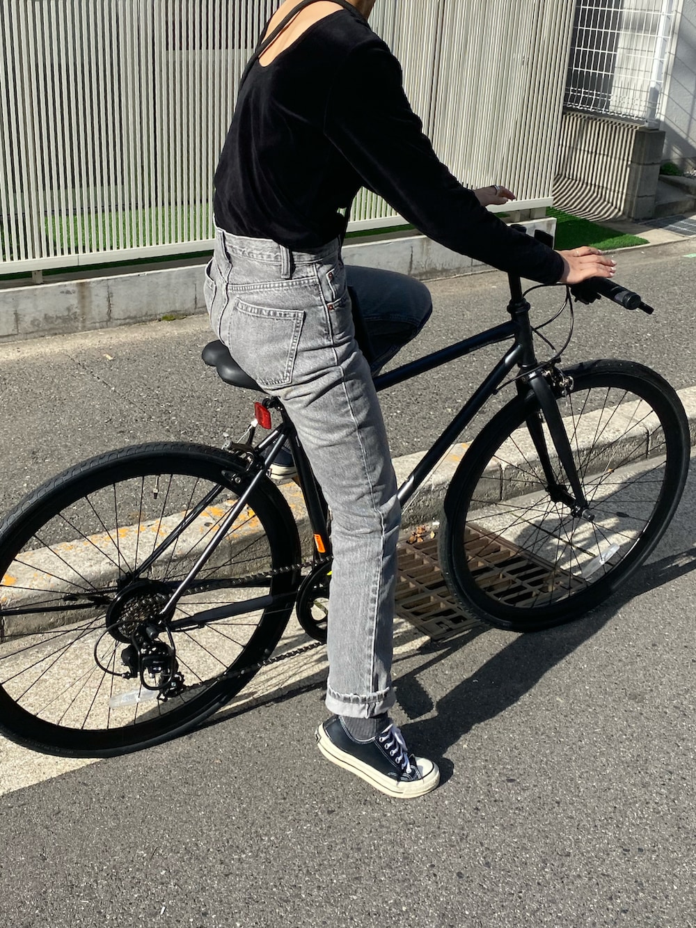 ブラック系のTシャツ/カットソー、グレー系のデニムパンツを着用したレディースの春コーディネートの2枚目の写真