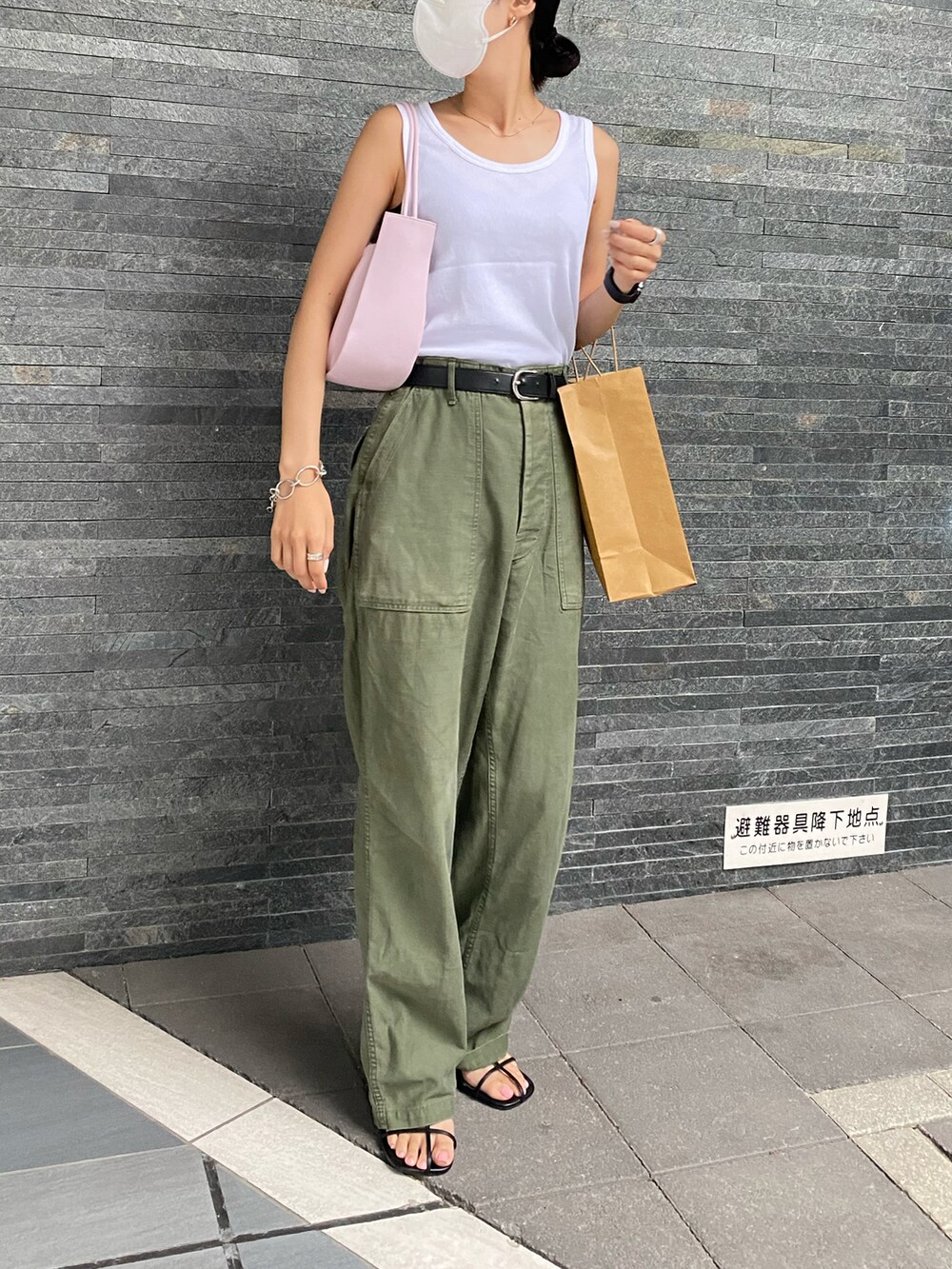 グリーン系のパンツ、ブラック系のサンダル、ピンク系のショルダーバッグを着用したレディースの夏コーディネートの2枚目の写真