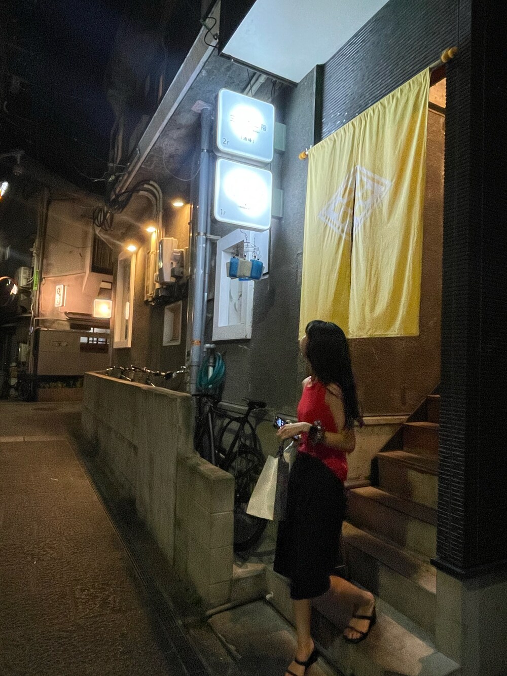 ブラック系のサンダル、ブルー系のスラックスを着用したレディースの夏コーディネートの4枚目の写真