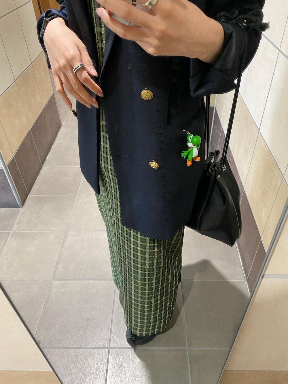 グリーン系のワンピース、ブルー系のテーラードジャケット、ブラック系のスニーカーを着用したレディースの春コーディネートの2枚目の写真