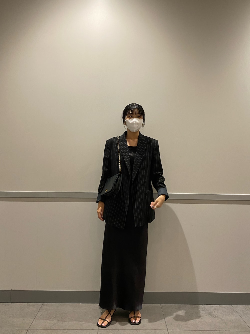 ブラック系のショルダーバッグ、ブラック系のワンピース、ブラック系のサンダルを着用したレディースの夏コーディネートの2枚目の写真