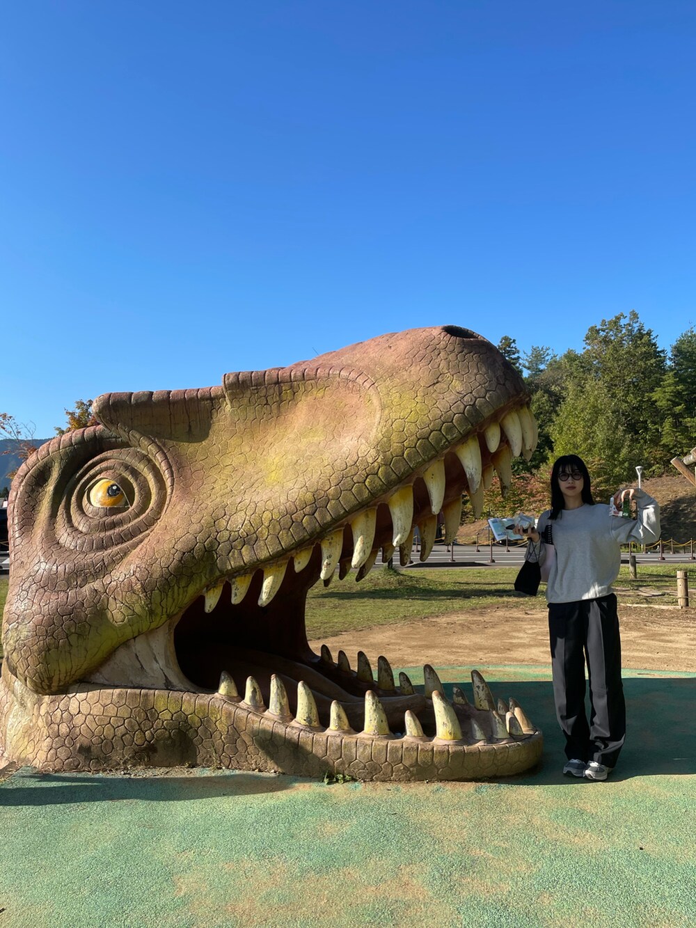 ピンク系のショルダーバッグ、ブルー系のスラックスを着用したレディースの秋コーディネートの5枚目の写真