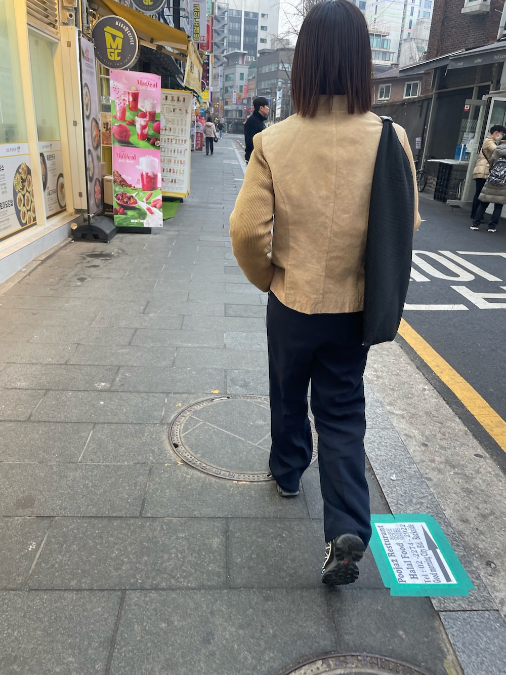 ブラック系のトートバッグ、ブルー系のスラックス、ブラック系のスニーカーを着用したレディースの春コーディネートの3枚目の写真