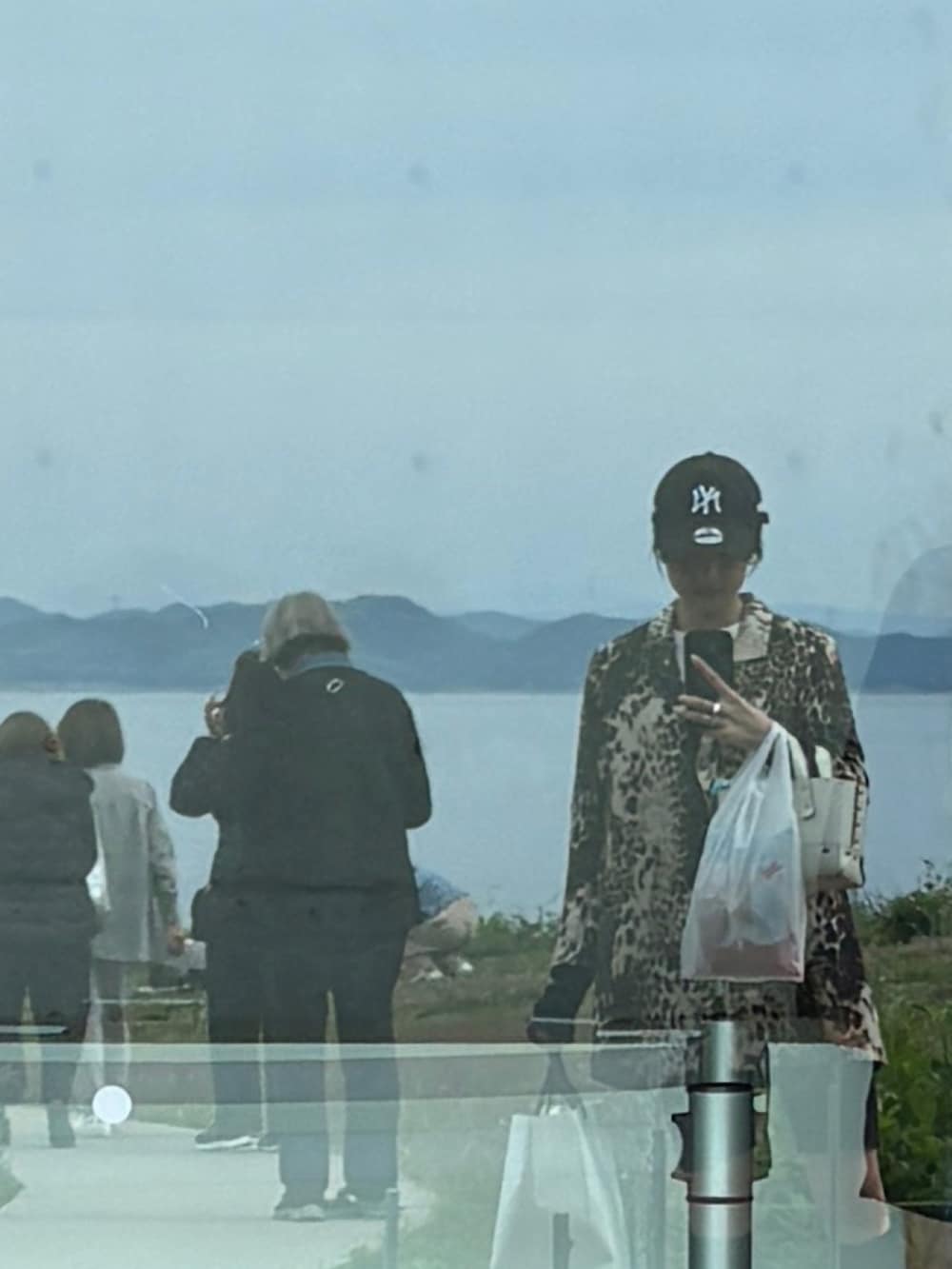 ホワイト系のハンドバッグを着用したレディースの夏コーディネートの2枚目の写真