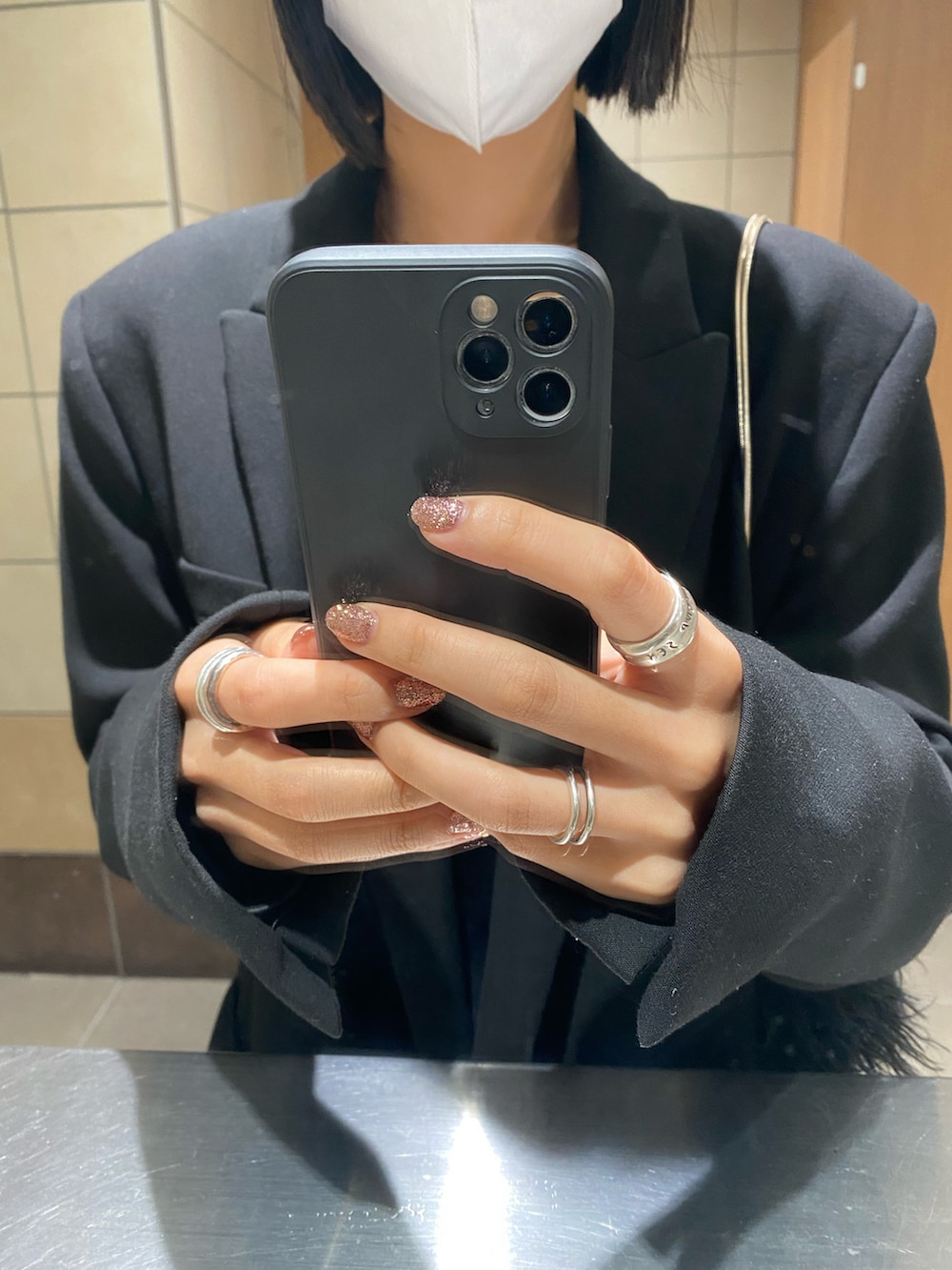 ブルー系のデニムパンツ、ブラック系のスニーカー、シルバー系のリングを着用したレディースの秋コーディネートの2枚目の写真