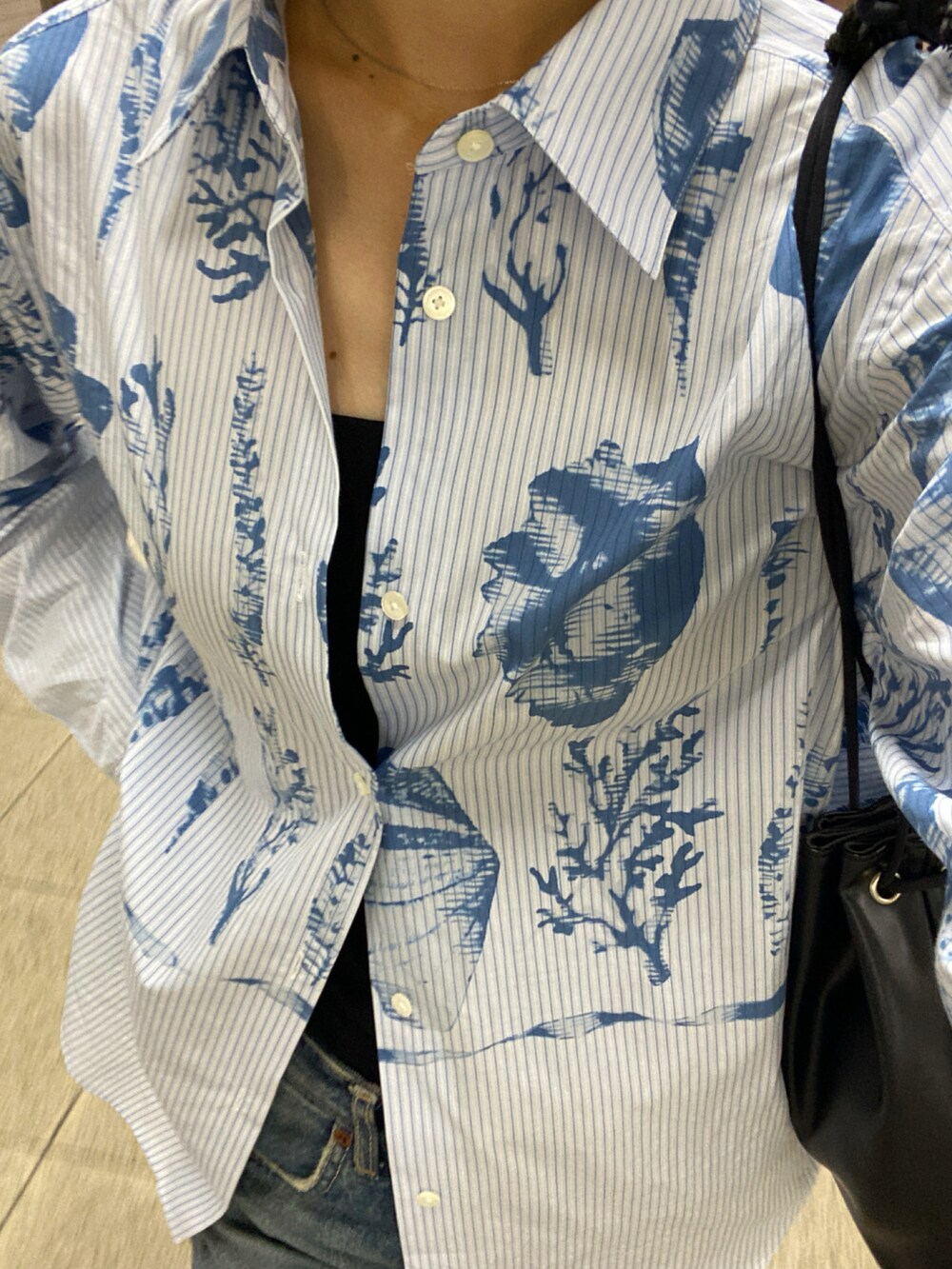 ブルー系のシャツ/ブラウスを着用したレディースの夏コーディネートの2枚目の写真