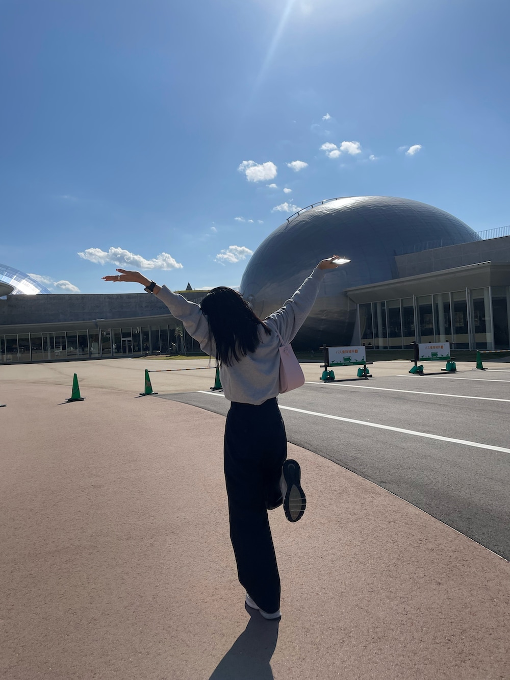 ピンク系のショルダーバッグ、ブルー系のスラックスを着用したレディースの秋コーディネートの3枚目の写真