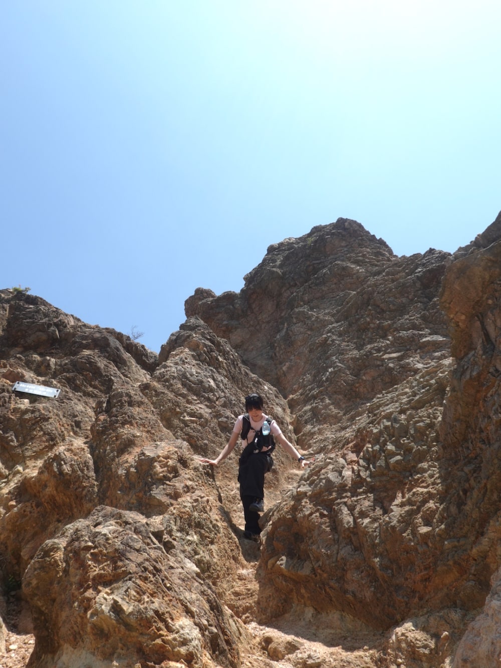 ブラック系のカーゴパンツ、ブラック系のバックパック/リュックを着用したレディースの夏コーディネートの2枚目の写真