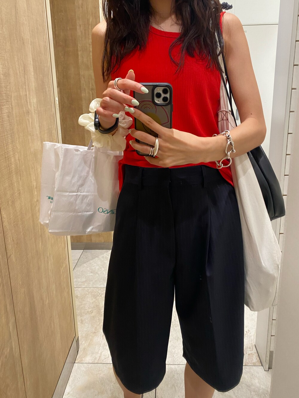 ブラック系のサンダル、ブルー系のスラックスを着用したレディースの夏コーディネートの5枚目の写真