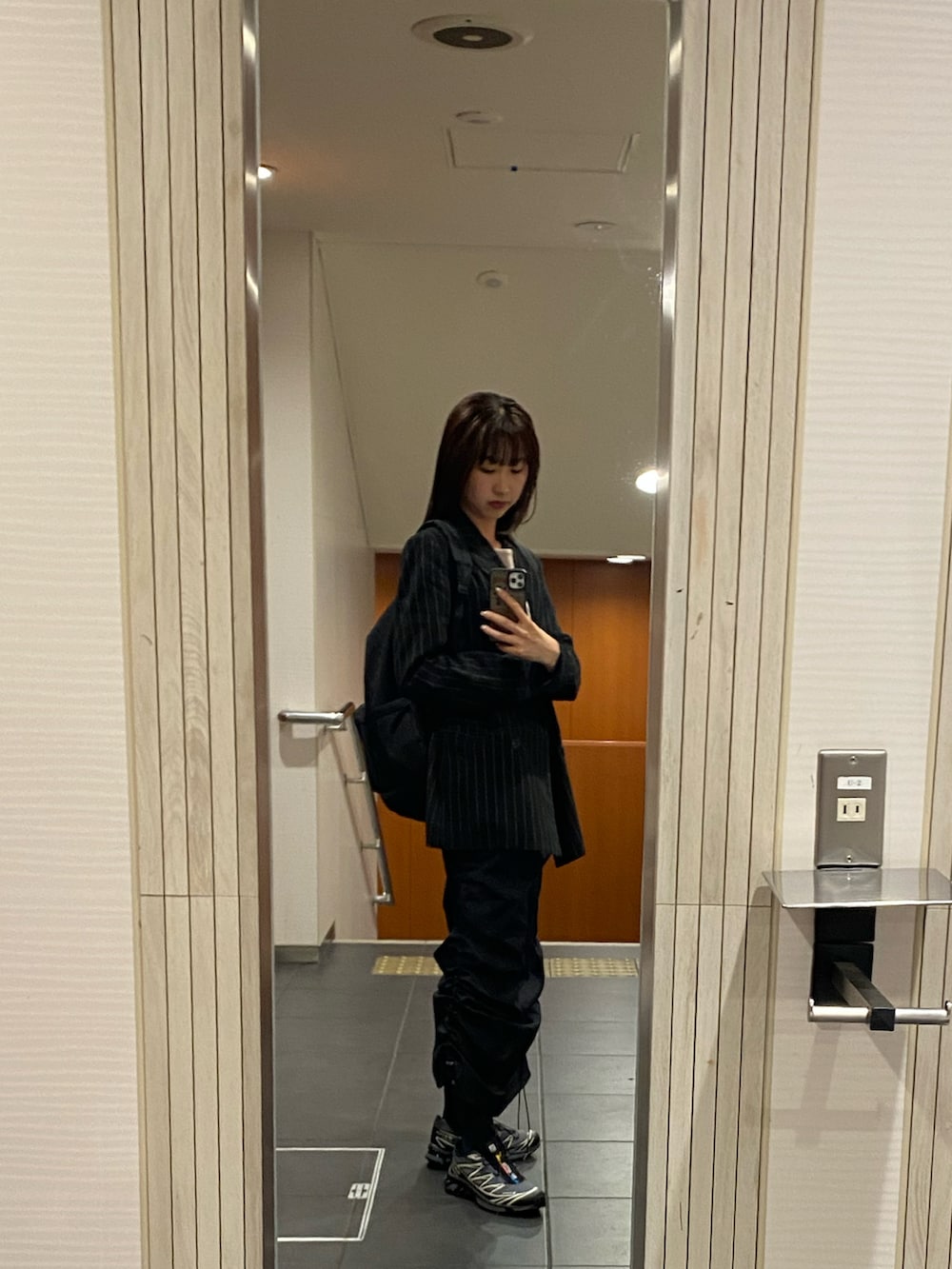 ブラック系のスカート、ブラック系のスニーカー、ピンク系のキャミソールを着用したレディースの春コーディネートの2枚目の写真