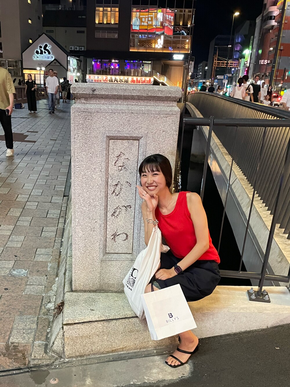 ブラック系のサンダル、ブルー系のスラックスを着用したレディースの夏コーディネートの2枚目の写真