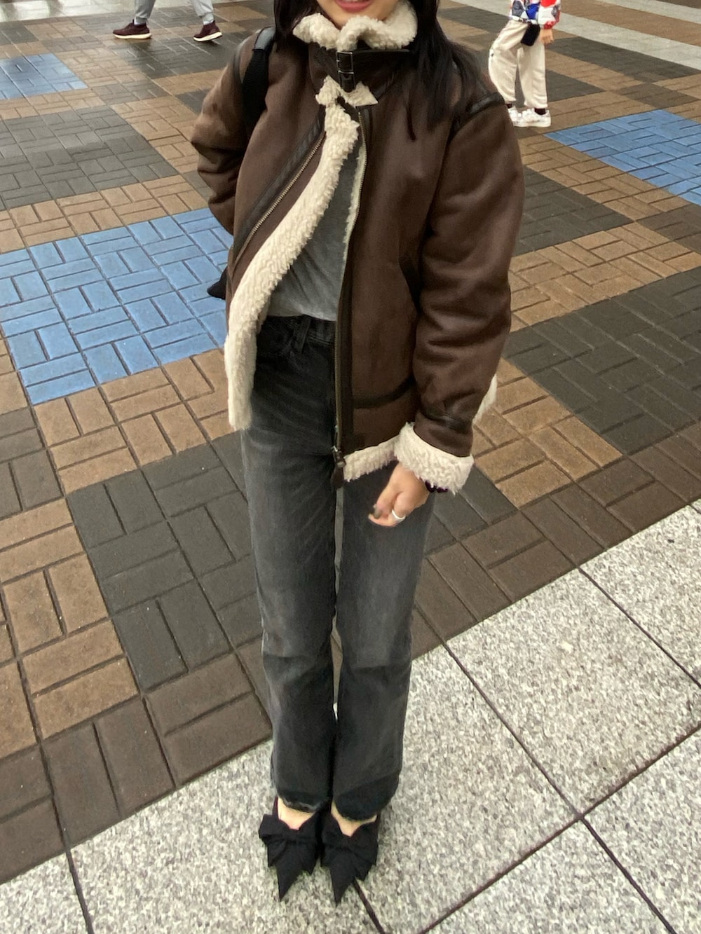 ブラック系のトートバッグ、ブラック系のデニムパンツ、ブラック系のパンプスを着用したレディースの春コーディネートの2枚目の写真