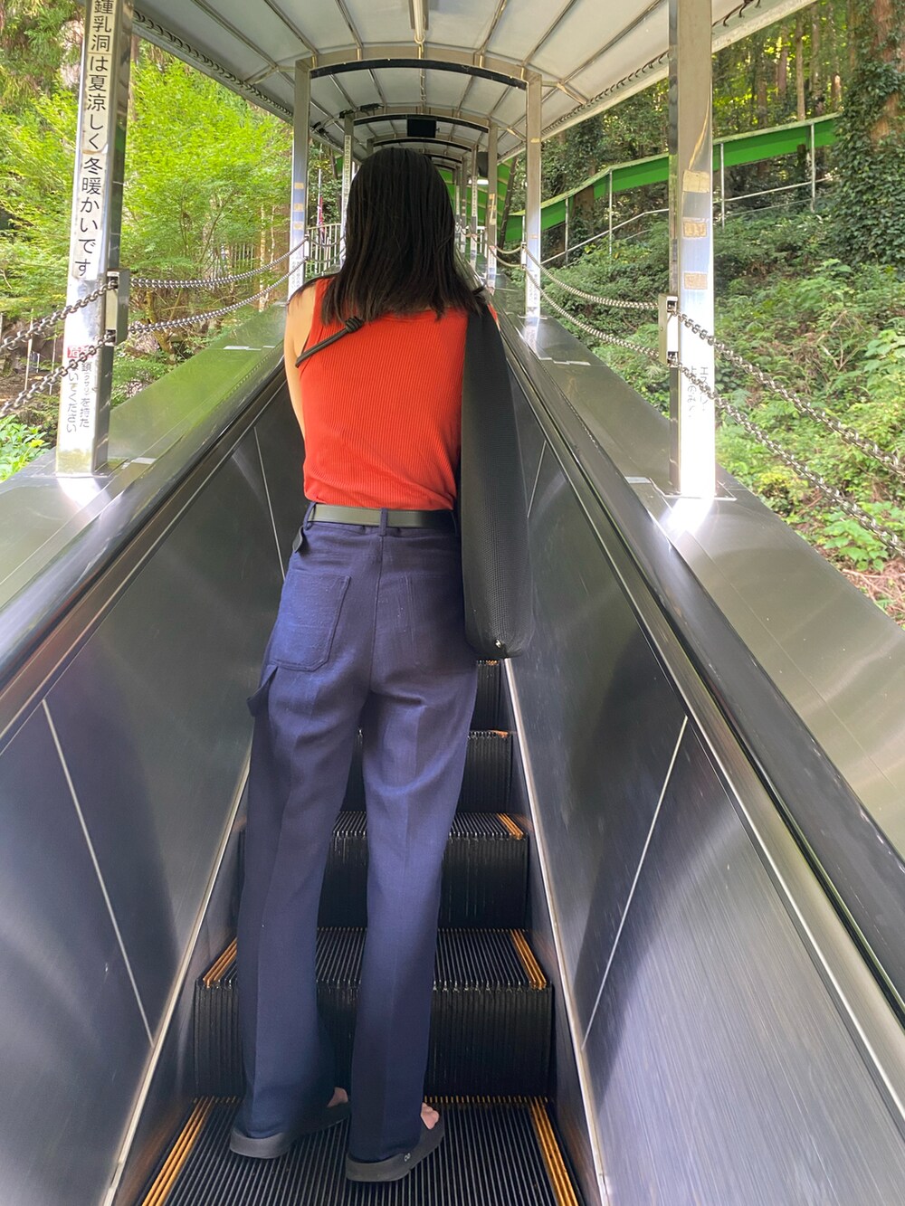 ブラック系のトートバッグ、ブルー系のその他パンツ、ブラック系のサンダルを着用したレディースの夏コーディネートの2枚目の写真