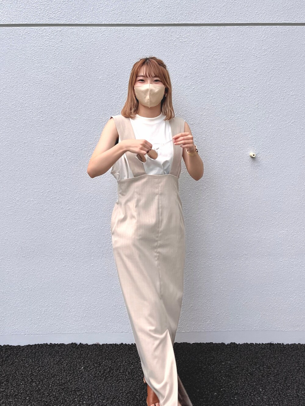 ホワイト系のトップス、ベージュ系のジャンパースカートを着用したレディースの夏コーディネートの2枚目の写真