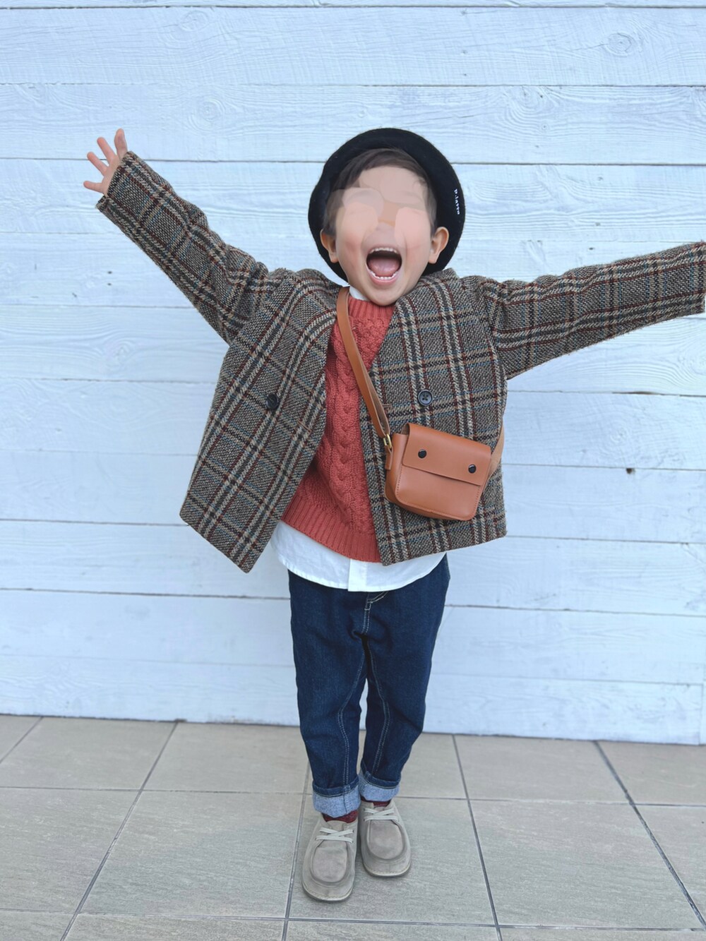 ブラウン系のノーカラージャケット、レッド系のニット/セーター、ホワイト系のシャツ/ブラウスを着用したキッズの冬コーディネートの2枚目の写真