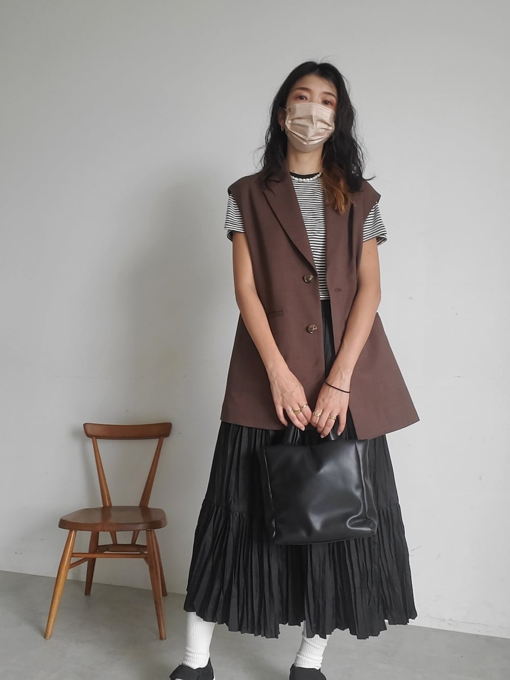 その他のTシャツ/カットソー、ブラウン系のベスト、ブラック系のスカートを着用したレディースの秋コーディネートの3枚目の写真