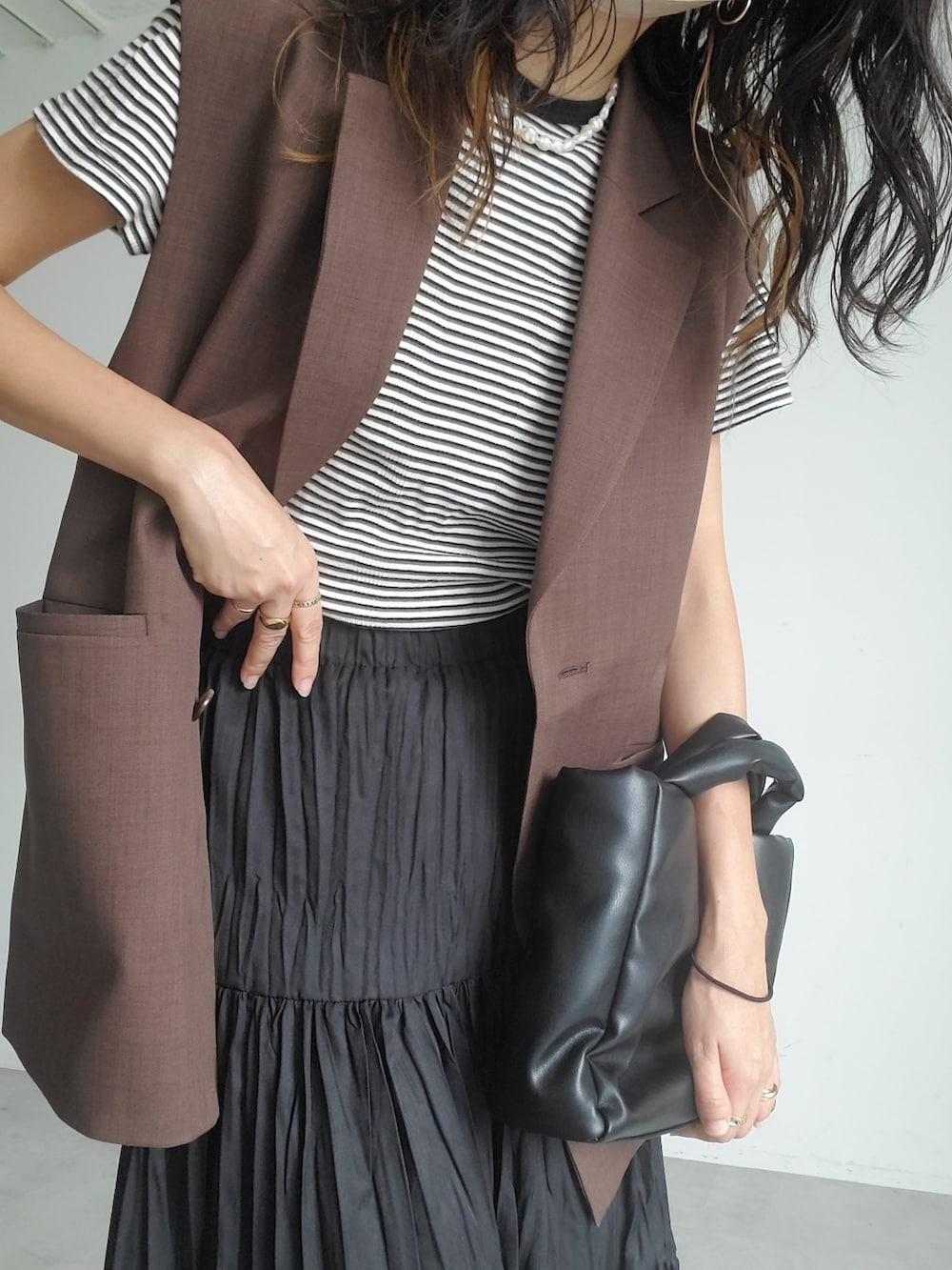その他のTシャツ/カットソー、ブラウン系のベスト、ブラック系のスカートを着用したレディースの秋コーディネートの4枚目の写真