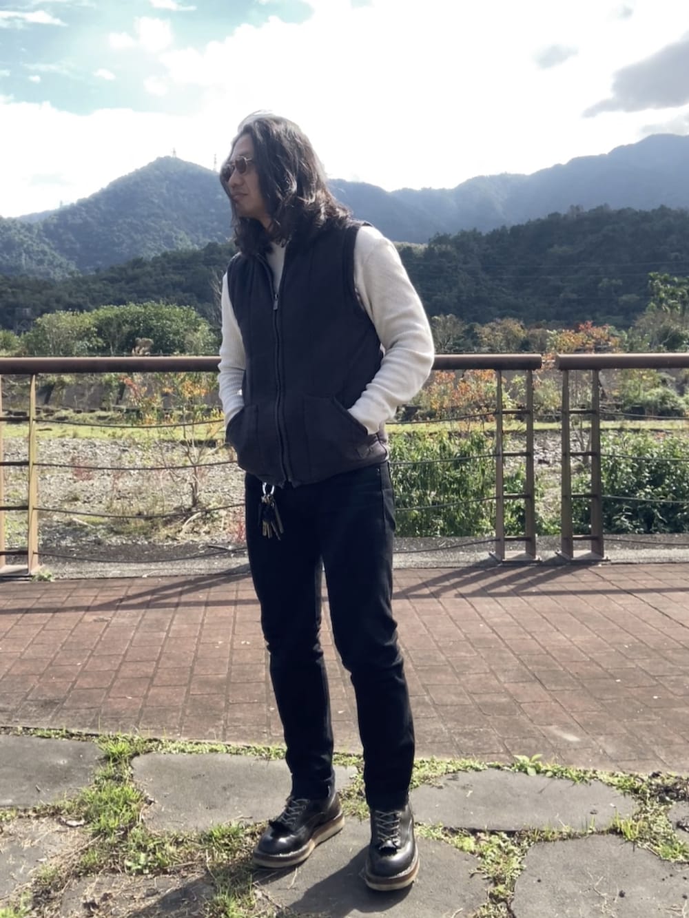 ブラック系のその他アウター、ブラック系のブーツ、ベージュ系のTシャツ/カットソーを着用したメンズの冬コーディネートの2枚目の写真