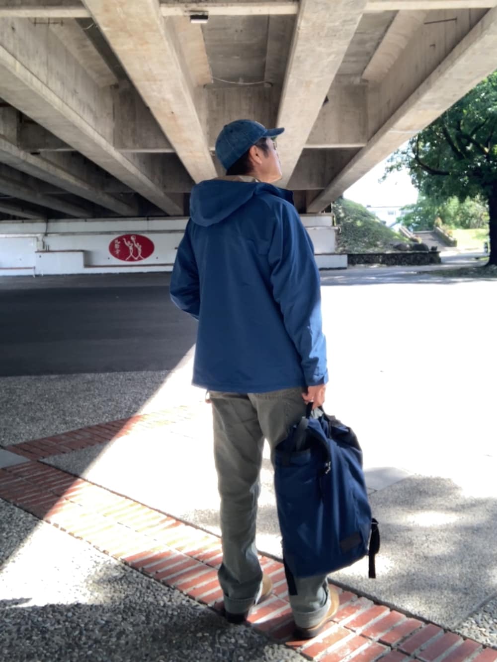 ブルー系のバックパック/リュック、グレー系のTシャツ/カットソー、グリーン系のその他パンツを着用したメンズの冬コーディネートの2枚目の写真