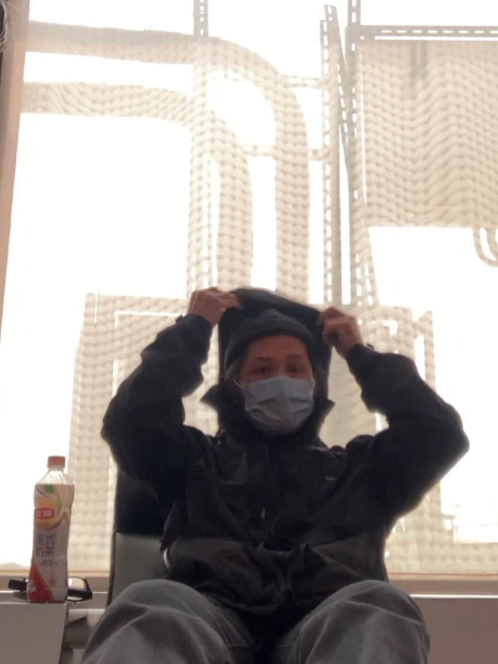 ブラック系のナイロンジャケット、グレー系のその他パンツ、オレンジ系のTシャツ/カットソーを着用したメンズの春コーディネートの2枚目の写真