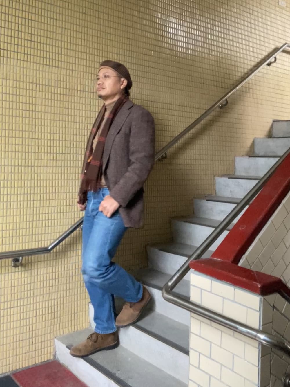 ブラウン系のテーラードジャケット、ブラウン系のニット/セーター、ブルー系のデニムパンツを着用したメンズの冬コーディネートの4枚目の写真