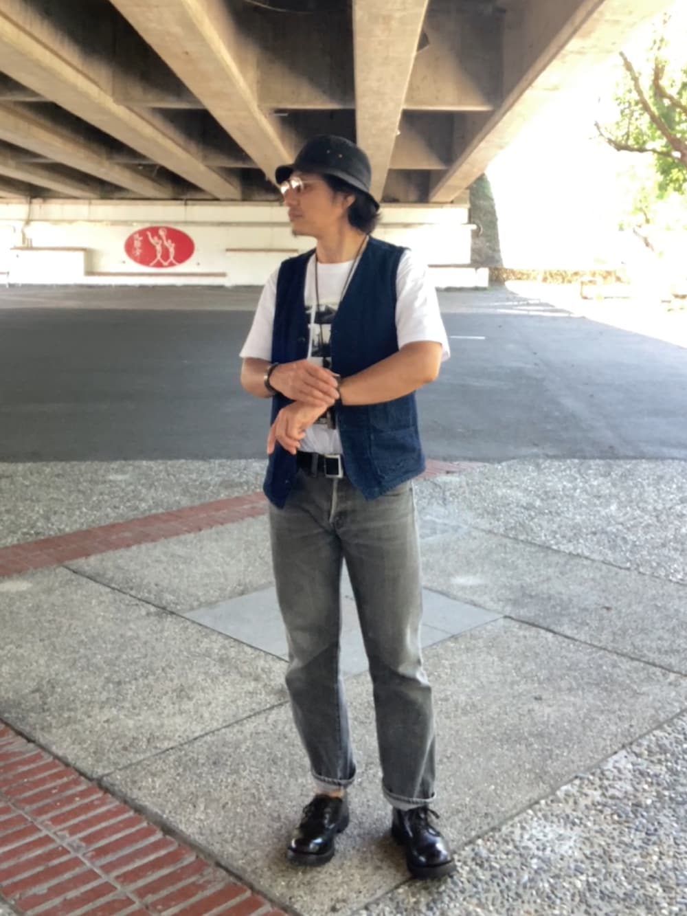 ブルー系のベスト、ホワイト系のTシャツ/カットソー、ブラック系のデニムパンツを着用したメンズの夏コーディネートの2枚目の写真