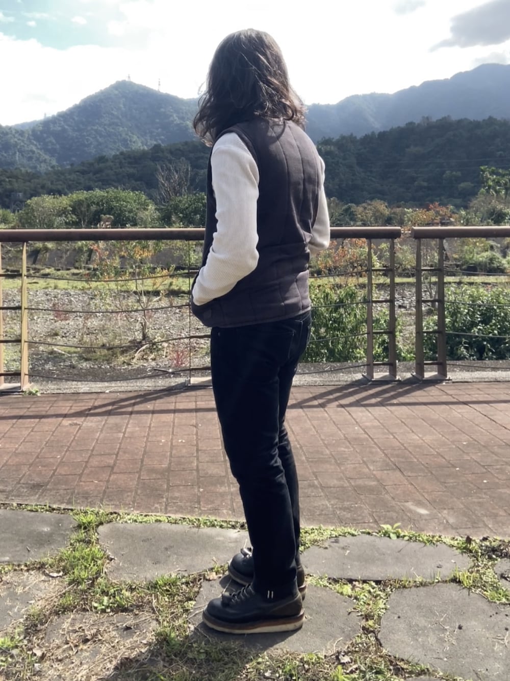 ブラック系のその他アウター、ブラック系のブーツ、ベージュ系のTシャツ/カットソーを着用したメンズの冬コーディネートの3枚目の写真