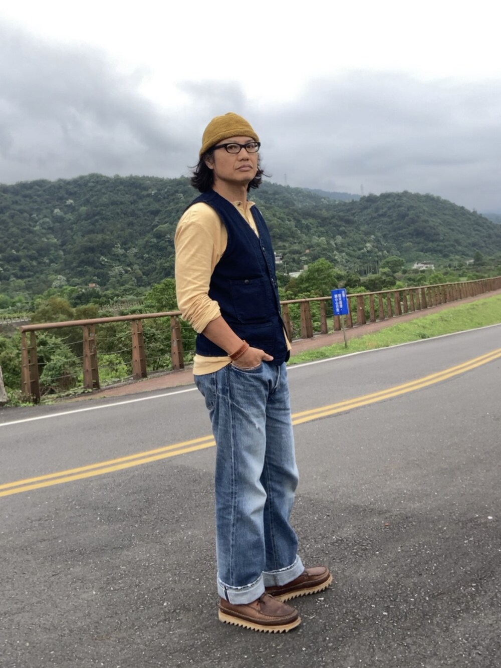 ブラウン系のブーツ、ブルー系のベスト、ブルー系のその他アウターを着用したメンズの春コーディネートの3枚目の写真