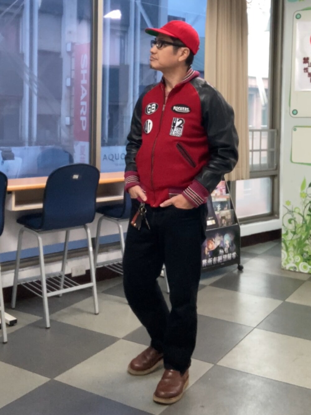 レッド系のスタジャン、ブラック系のデニムパンツ、ブラウン系のスリッポンを着用したメンズの秋コーディネートの2枚目の写真
