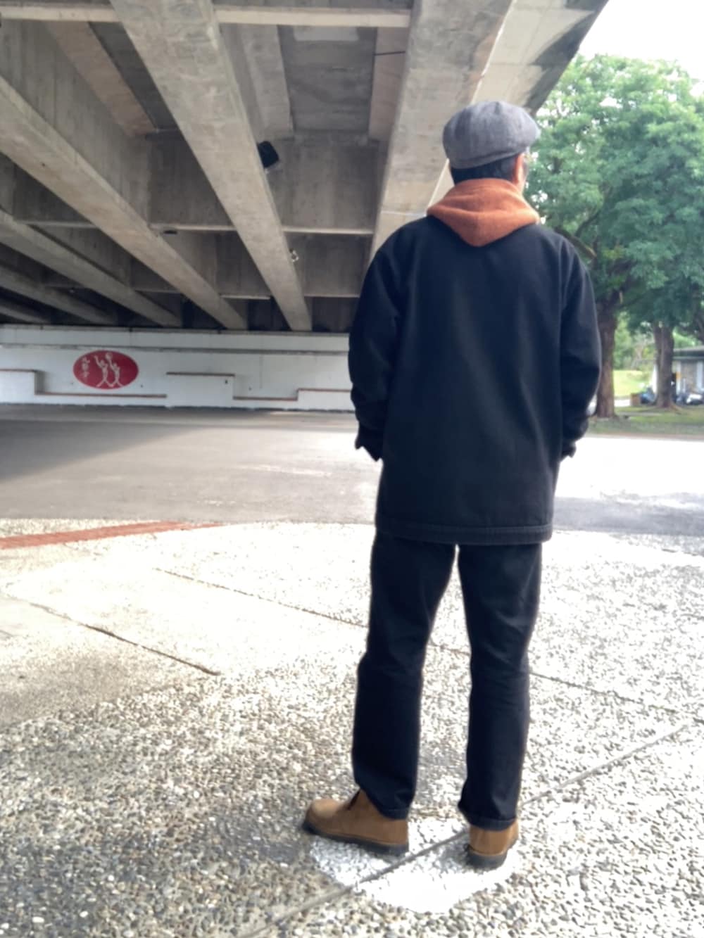 ブラウン系のベスト、ブラウン系のTシャツ/カットソー、ブラック系のカバーオールを着用したメンズの冬コーディネートの2枚目の写真