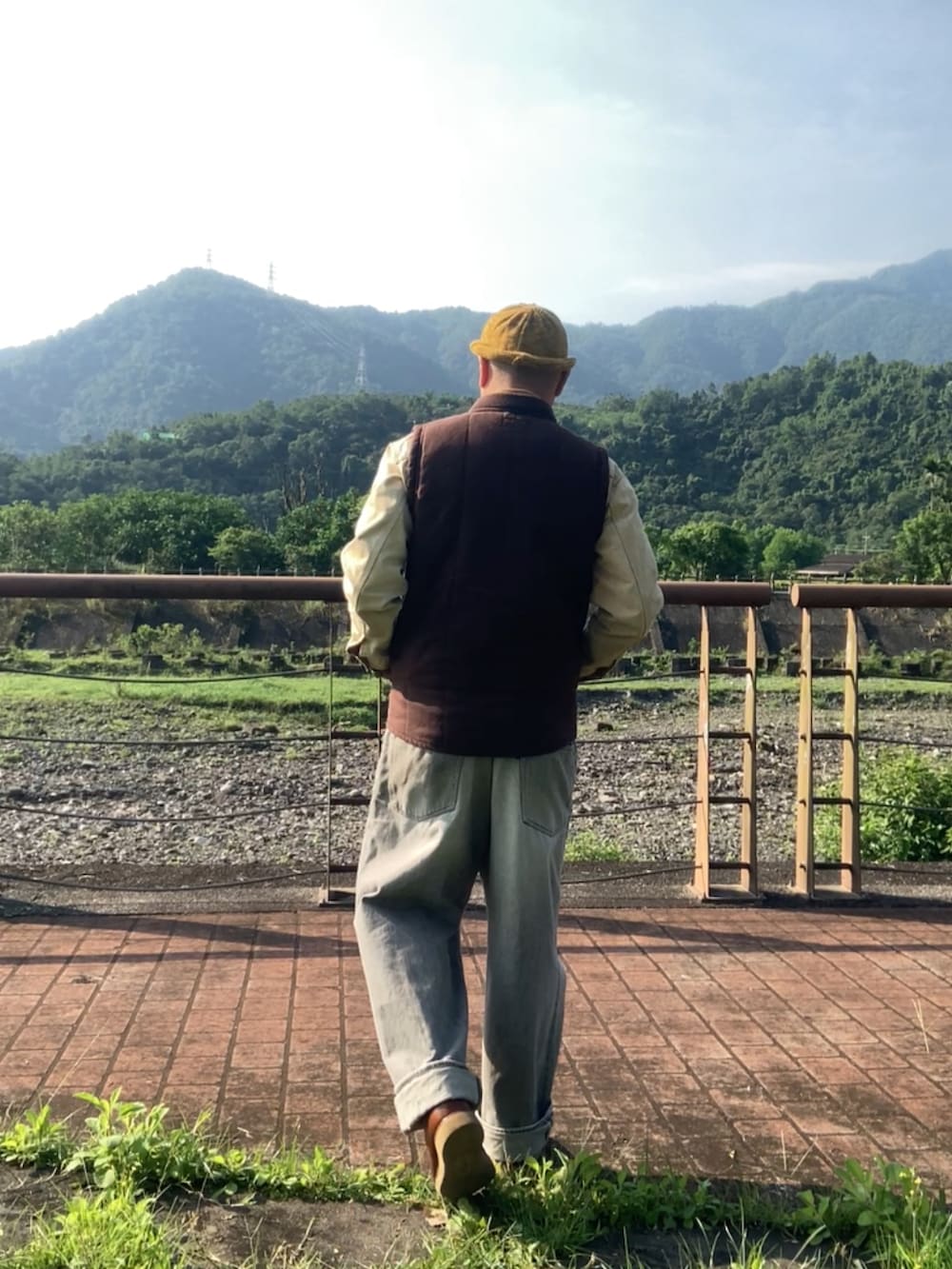 ベージュ系のデニムジャケット、ブラウン系のスリッポン、レッド系のその他アウターを着用したメンズの春コーディネートの3枚目の写真