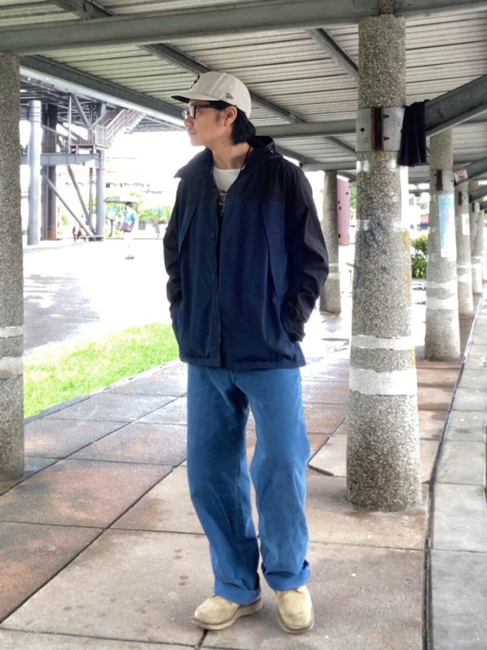 ブルー系のベスト、ブルー系のチノパンツ、ベージュ系のブーツを着用したメンズの春コーディネートの2枚目の写真