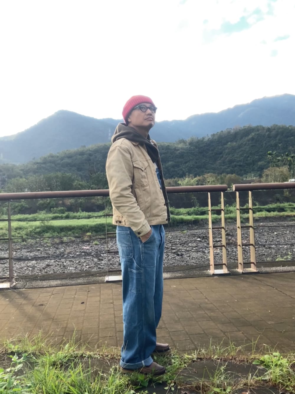 ベージュ系のデニムジャケット、ブルー系のサロペット/オーバーオール、ブラウン系のブーツを着用したメンズの冬コーディネートの4枚目の写真