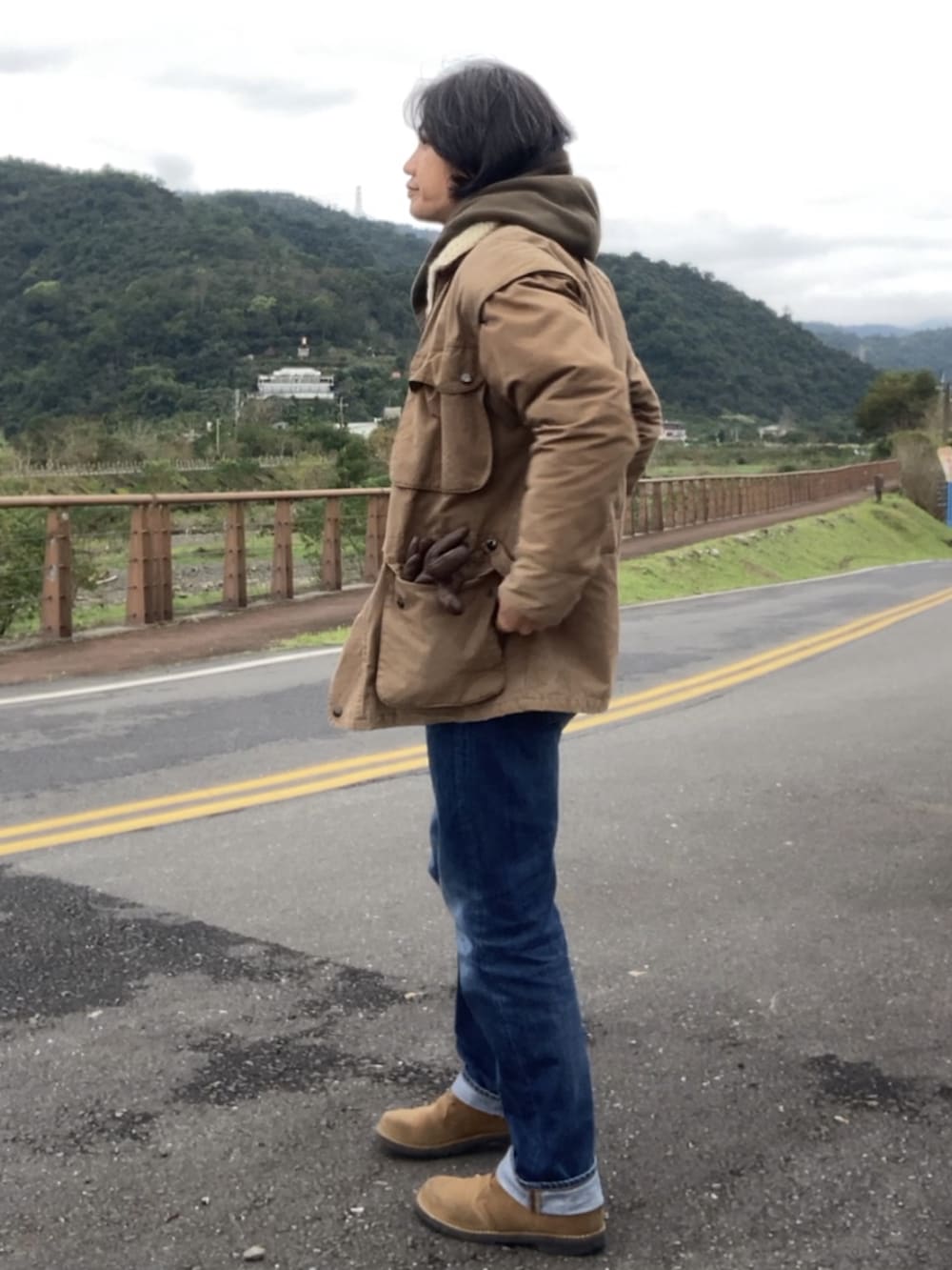 ブラウン系のジャケット/アウター、ブルー系のデニムパンツ、ブラウン系のブーツを着用したメンズの冬コーディネートの3枚目の写真