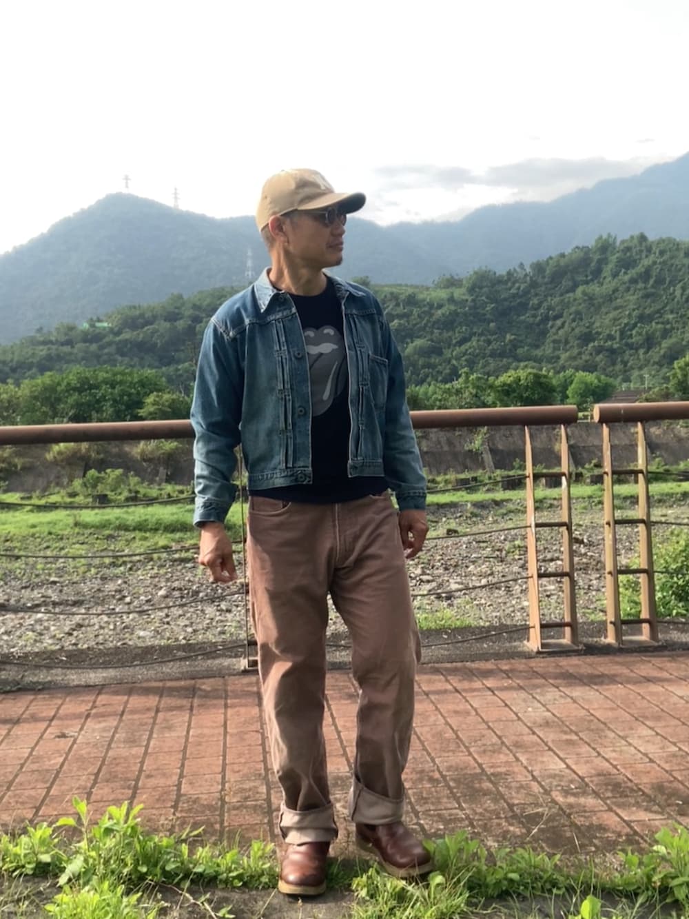 ブルー系のデニムジャケット、ブラック系のTシャツ/カットソー、ブラウン系のその他パンツを着用したメンズの春コーディネートの4枚目の写真