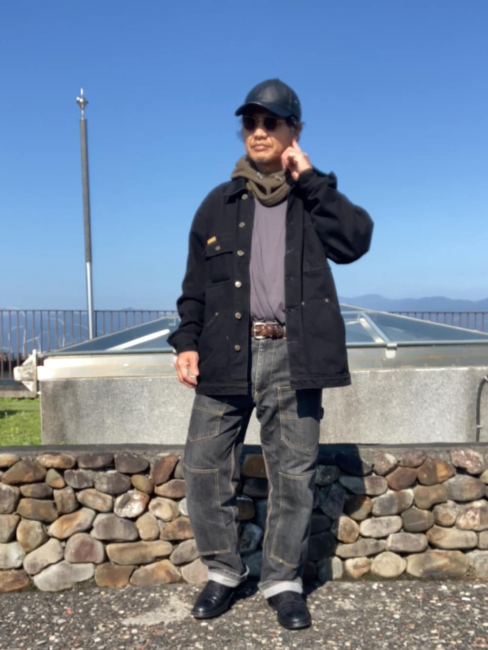 ブラック系のカバーオール、ブラック系のデニムパンツ、ブラック系のドレスシューズを着用したメンズの冬コーディネートの2枚目の写真