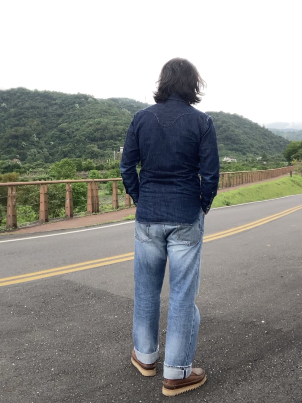 ブルー系のデニムパンツ、ブラウン系のブーツ、ブルー系のシャツ/ブラウスを着用したメンズの春コーディネートの3枚目の写真