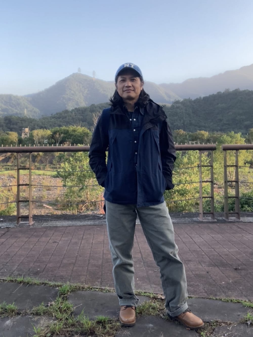 ブルー系のバックパック/リュック、ブラック系のマウンテンパーカー、グリーン系のその他パンツを着用したメンズの冬コーディネートの3枚目の写真