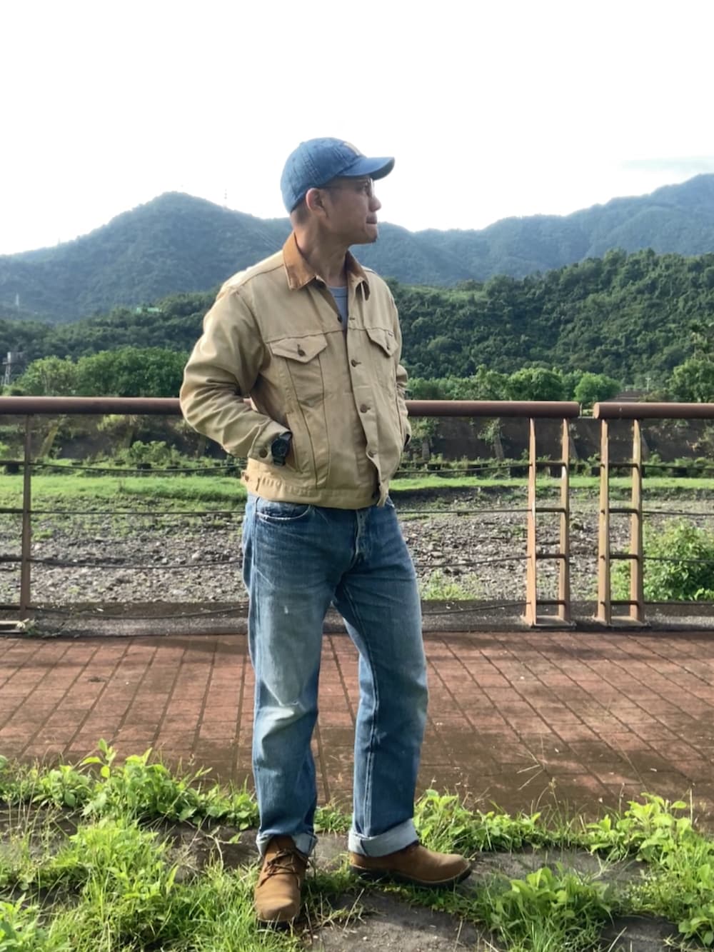 ベージュ系のデニムジャケット、ブルー系のデニムパンツ、ブラウン系のブーツを着用したメンズの春コーディネートの4枚目の写真