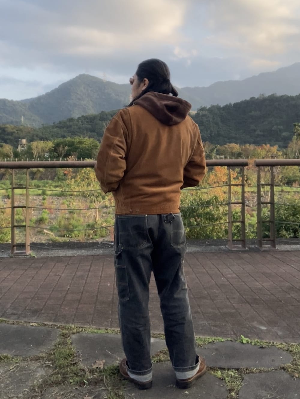 ブラウン系のその他アウター、ブラック系のデニムパンツ、ブラウン系のブーツを着用したメンズの冬コーディネートの3枚目の写真