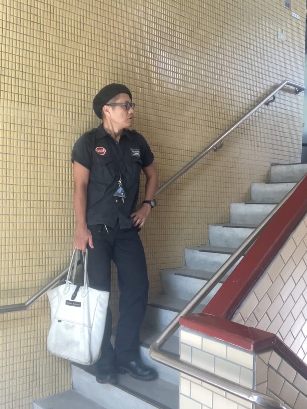 ホワイト系のトートバッグ、ブラック系のシャツ/ブラウス、ブラック系のチノパンツを着用したメンズの秋コーディネートの2枚目の写真