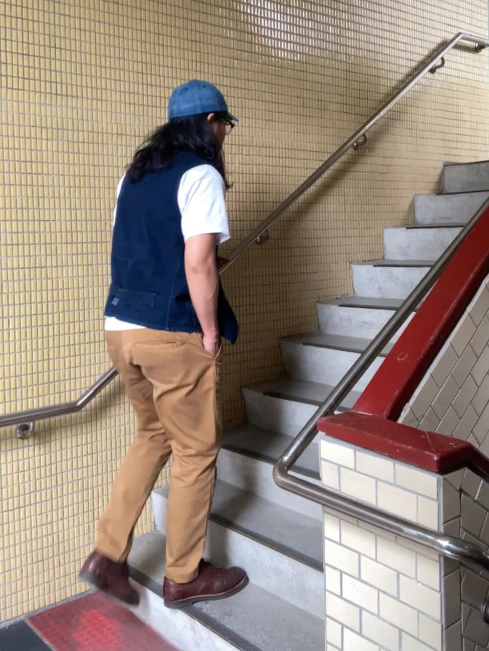 ブラウン系のチノパンツ、ブルー系のベスト、ブラウン系のその他シューズを着用したメンズの春コーディネートの3枚目の写真