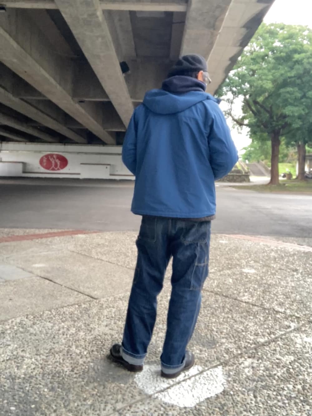 ブルー系のパーカー、グレー系のピーコート、ブルー系のマウンテンパーカーを着用したメンズの冬コーディネートの3枚目の写真